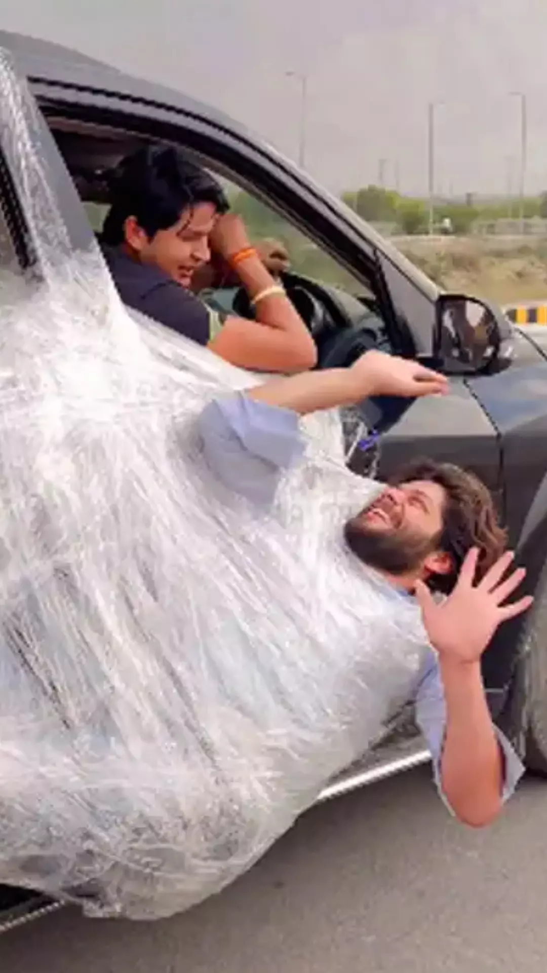 Man Hangs On Car Door To Sleep